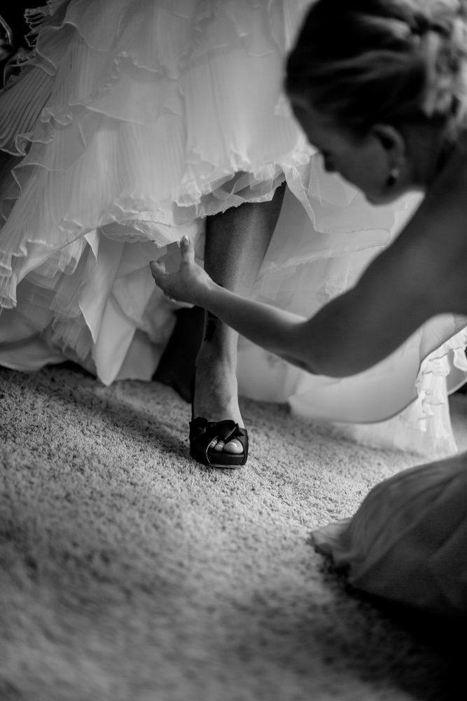 A bride adorning her wedding shoes.
