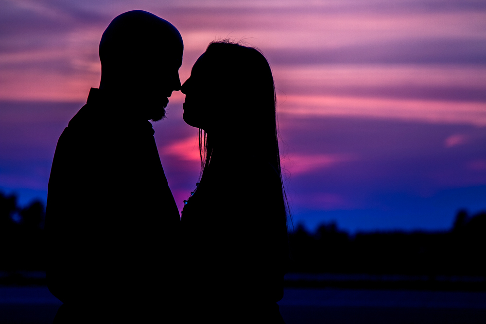 A silhouette of a couple kissing at a country wedding.
