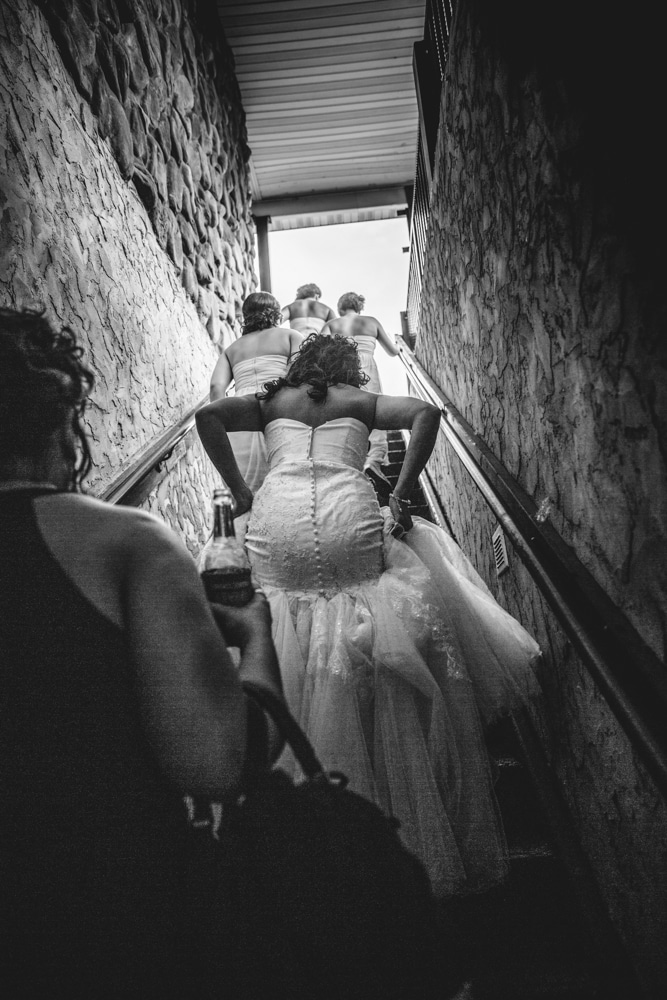 Bridesmaids gracefully descending stairs captured by Onalaska Photography.
