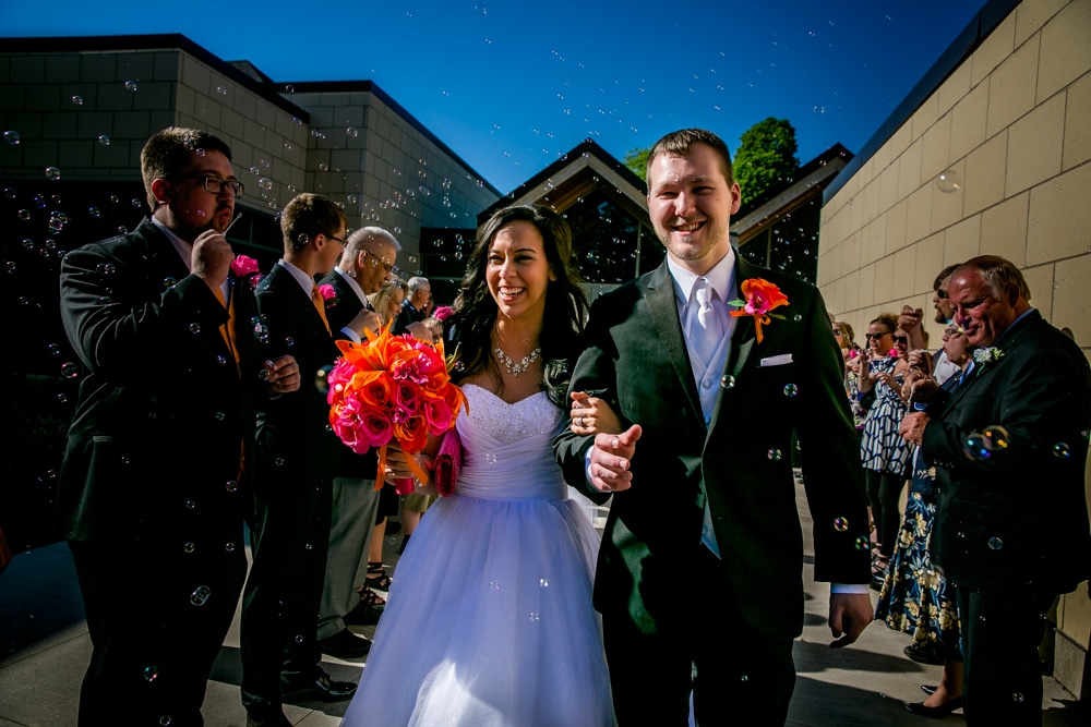A La Crosse wedding couple exit a church with bubbles.