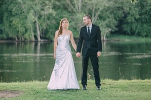 A La Crosse WI bride and groom holding hands in front of a lake.