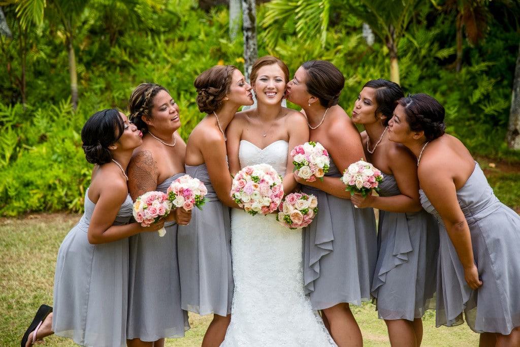 A bride and her bridesmaids are posing for a picture.