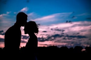 A silhouette of a bride and groom at sunset.