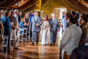 A Rochester MN Wedding Photographer captures a bride walking down the aisle with her father.
