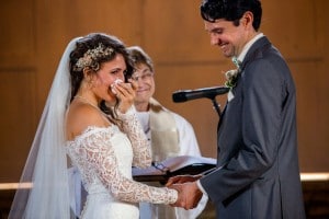 A bride and groom are shedding joyful tears during their wedding ceremony, captured by a Rochester MN Wedding Photographer.