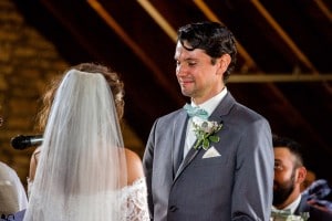 A bride and groom exchange glances during their wedding ceremony, captured by a skilled Rochester MN Wedding Photographer.