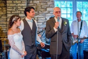 A Rochester MN wedding photographer captures a man speaking into a microphone.