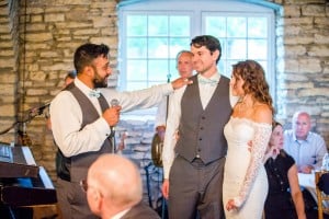 Rochester MN Wedding Photographer captures a bride and groom sharing a microphone at their reception.