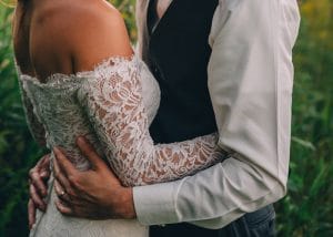 A bride and groom embracing in a picturesque field, captured by a skilled Rochester MN wedding photographer.