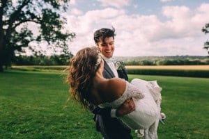 A bride and groom posing in a field near Mayowood Stone Barn.