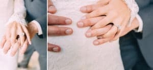 A bride and groom's hands holding wedding rings at Mayowood Stone Barn.