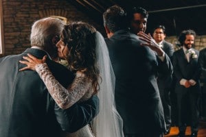 A Mayowood Stone Barn wedding ceremony with a bride and groom hugging.