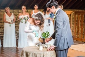 A bride and groom planting a plant at their wedding at Mayowood Stone Barn.