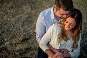 A couple has an adventurous engagement session on the sand.