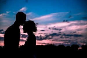 A stunning silhouette of a bride and groom in beautiful wedding photos at sunset.
