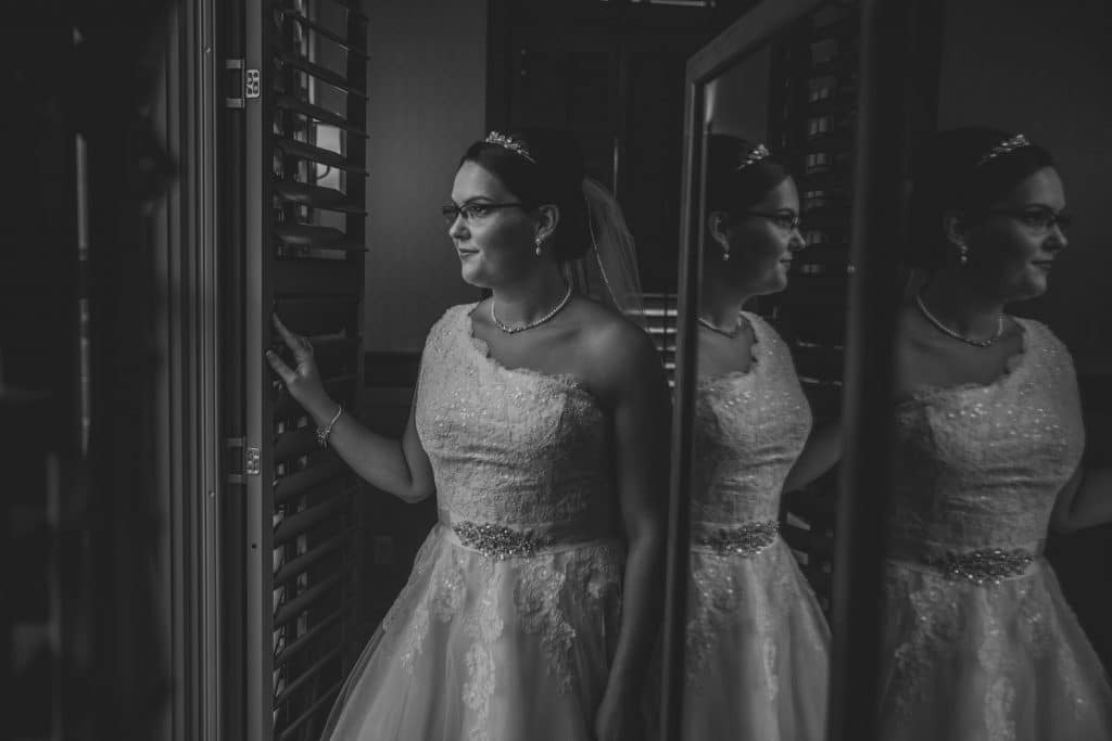 A bride at Noah's Event Center admiring herself in a wedding dress.
