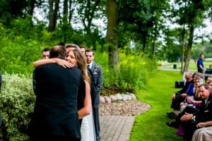 A bride and groom sharing a moody embrace during their wedding ceremony.