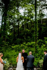 A moody bride and groom exchange vows in the woods, captured through stunning wedding photos.