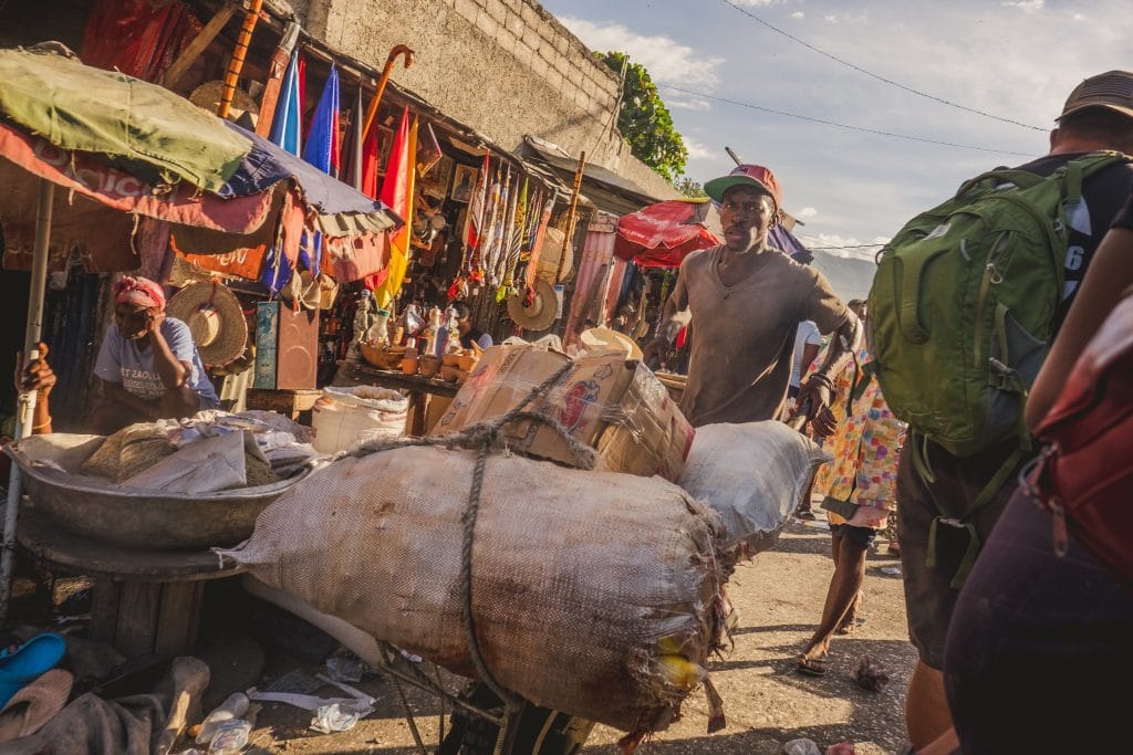 A group of people walking through a Haitian market.