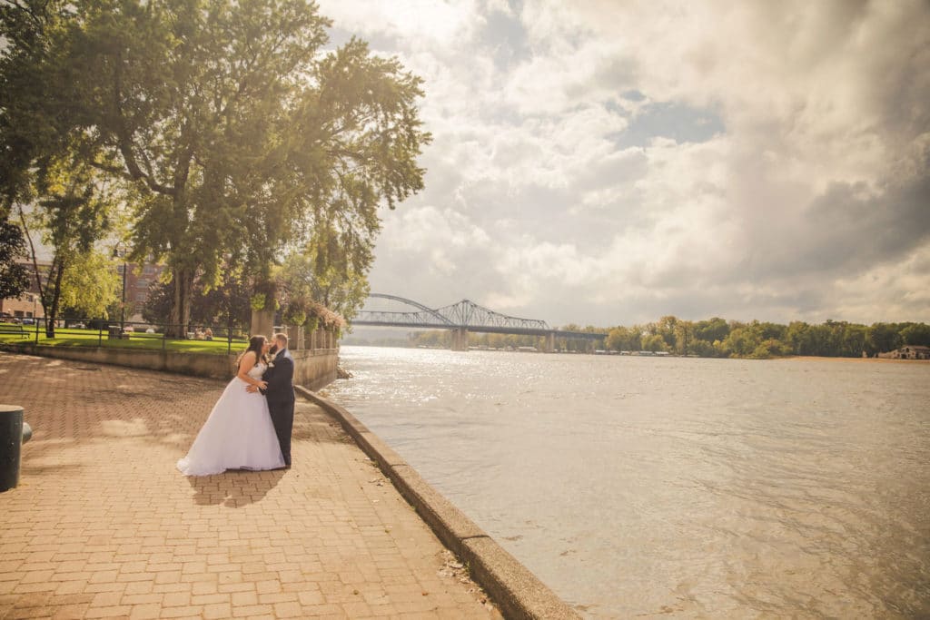 A nurse bride and groom posing by the river.