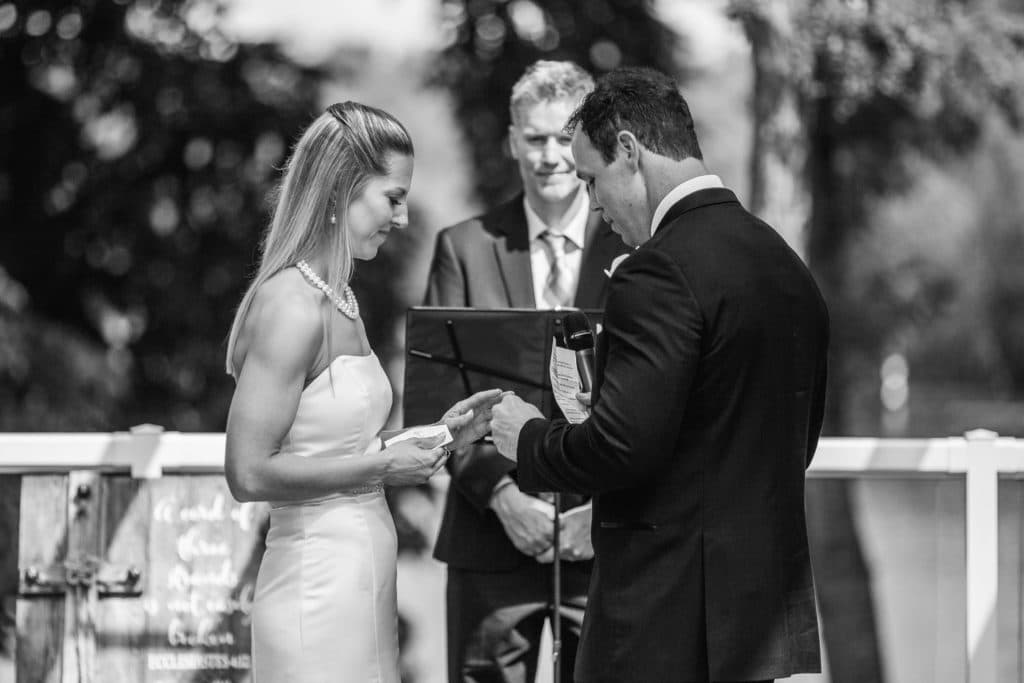 Black and white photo of a bride and groom exchanging their vows.