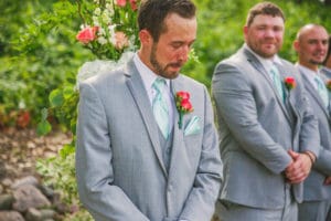 La Crosse WI Wedding Photographer captures a group of groomsmen surrounded by flowers.