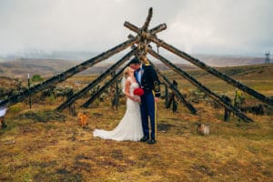 A bride and groom kiss in front of a tepee during their La Crosse wedding, beautifully captured by a Wisconsin photographer.