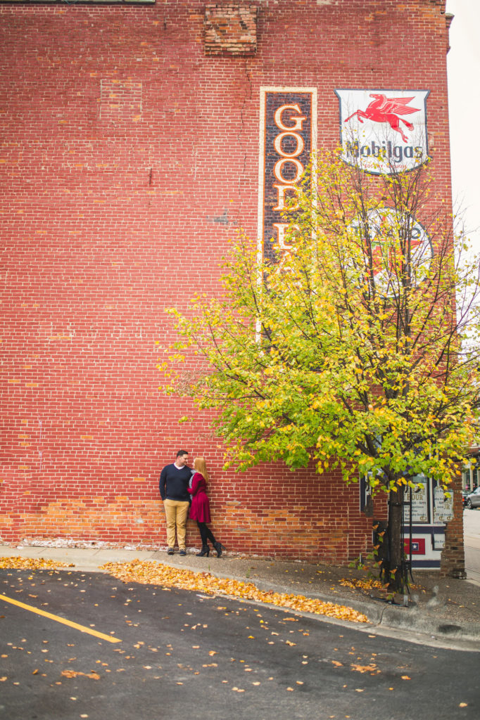 A couple having their La Crosse engagement in front of a red brick building.