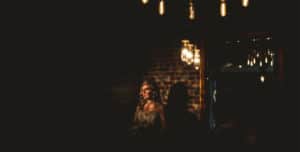 A bride is standing in front of a chandelier at a dog wedding.