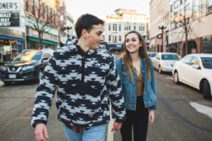 An engaged couple walking down a city street.