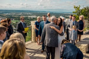 A bride and groom hugging at their wedding ceremony.