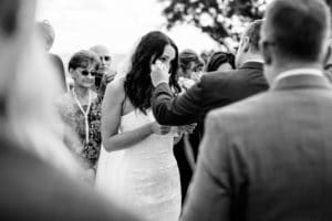 A bride is kissing her husband during a wedding ceremony.