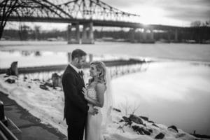 A couple exchanging vows in front of a bridge.