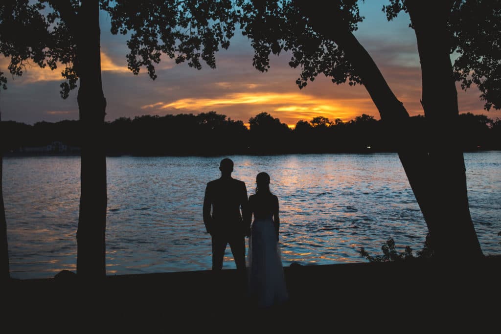 A Pump House Wedding couple at sunset by a lake.