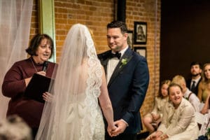A bride and groom exchange their vows at the intimate 4 Sisters Wine Bar wedding.