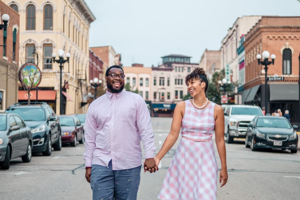 An engaged couple walking down a city street.