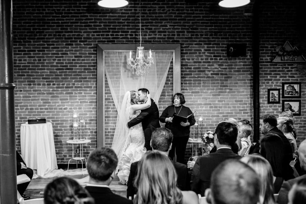 A bride and groom share a kiss at their 4 Sisters Wine Bar wedding.