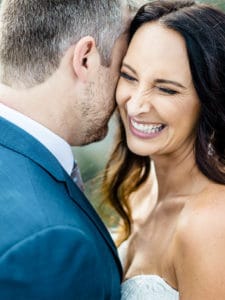 A couple sharing laughter at their wedding, representing the joyous beginnings of their journey.