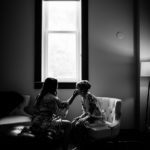 Black and white photo of two women getting ready in a room.