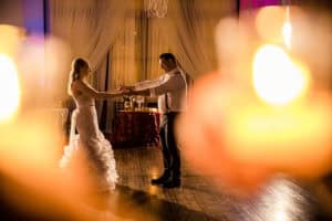 A bride and groom dancing in front of candles at The Court.