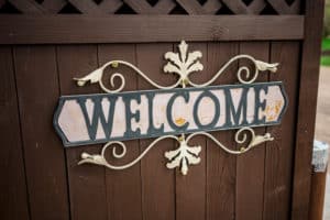 A welcome sign on a wooden fence.