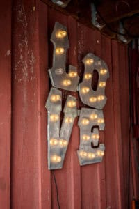 A metal sign with the word love hanging on it.