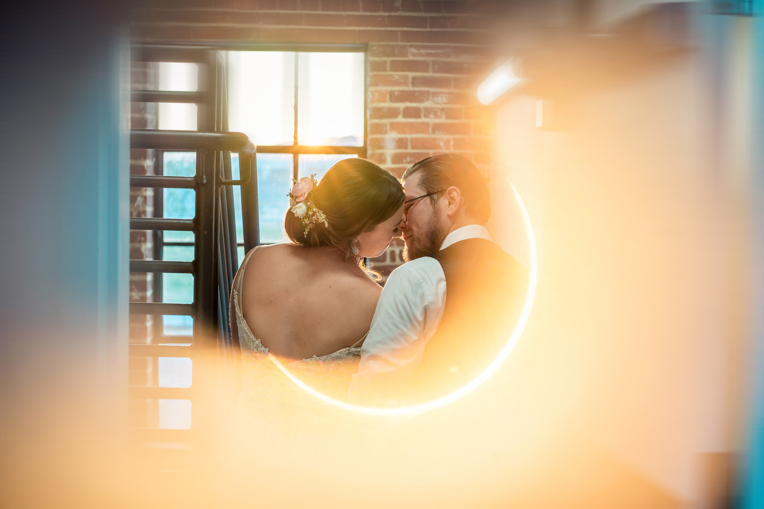 A bride and groom kissing in front of a mirror.