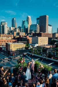 A wedding ceremony on a rooftop with the city skyline in the background.