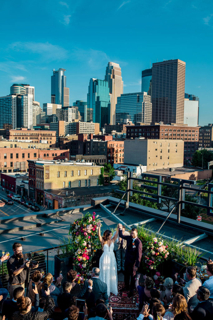 A wedding ceremony on a rooftop with a city skyline in the background.