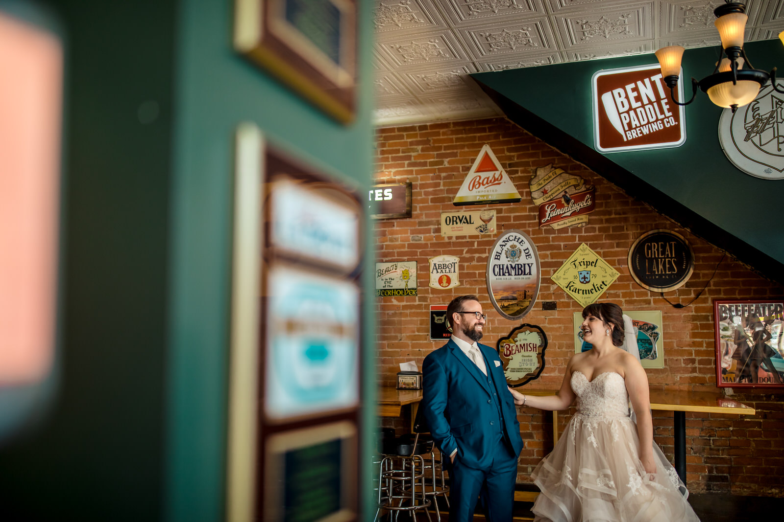 A bride and groom standing in front of a bar.