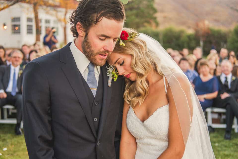 A bride and groom hugging during their wedding ceremony.