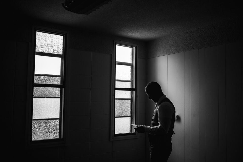 A silhouette of a man standing in front of a window.
