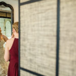 A bride getting ready in front of a mirror.