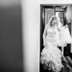 A bride is walking down the hallway in her wedding dress.